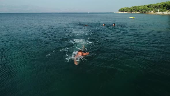 Tracking shot of family swimming in Adriatic sea.