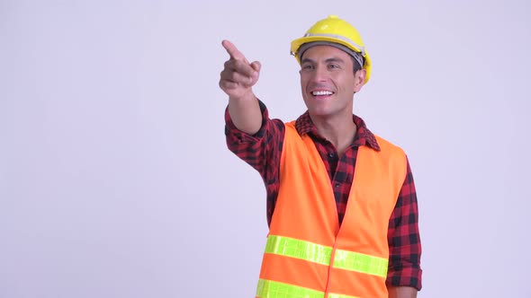 Young Happy Hispanic Man Construction Worker Directing and Pointing Finger