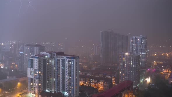 Night City with Skyscrapers and Luminous Windows at Thunderstorm and Lightning Flashes, Timelapse