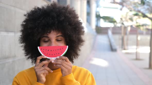 one happy and beauty cheerful woman holding a small watermelon covering her mouth