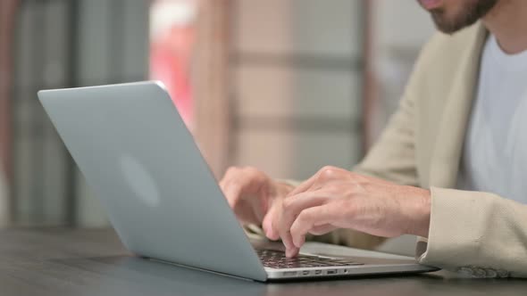 Close Up of Young Man Typing on Laptop Keyboard