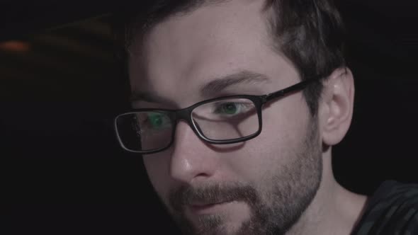 Closeup of male eyes looking at screen of laptop or computer, businessman working late at office