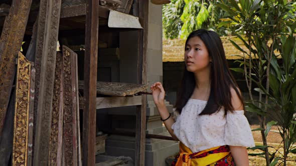 Teenage Chinese tourist explores a temple in Bali.