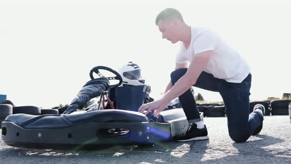 Attractive Man Checking Tire Pressure on His Gocart