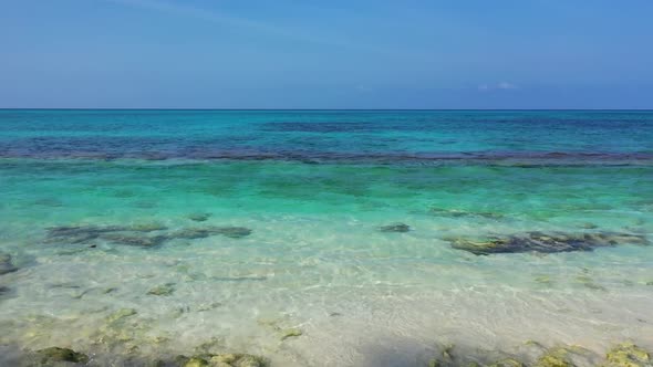 Aerial panorama of relaxing shore beach adventure by blue green ocean and white sand background of a