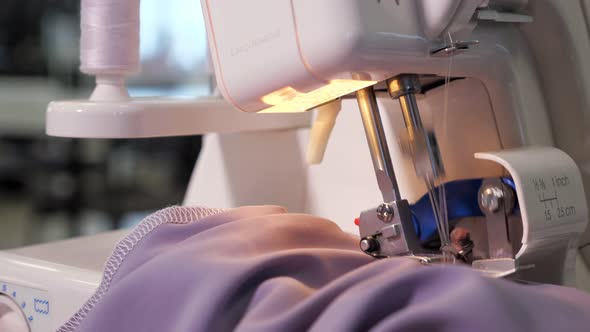 Seamstress Works at Sewing Machine Makes Straight Seams on Cloth Hands Closeup