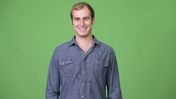Young Happy Man Smiling Against Green Background