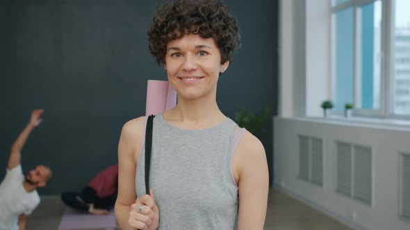 Portrait of Beautiful Young Woman in Yoga Studio Smiling Looking at Camera