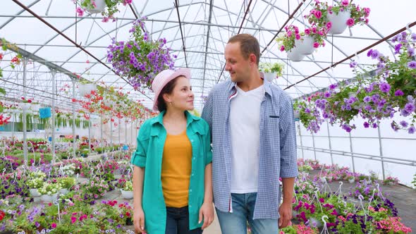 Young Agronomists Started Their Greenhouse Business Walk in Greenhouse with Happy Smiles on Faces