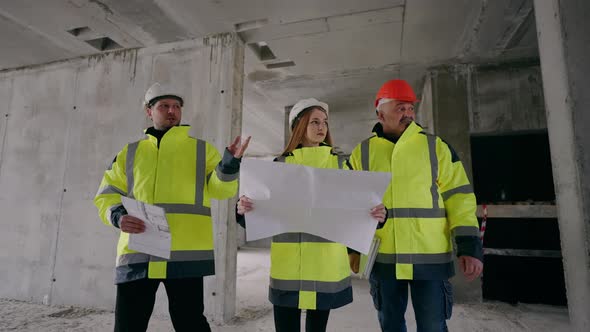 Young Female Architect and Two Male Civil Engineers are Checking Underconstruction Building