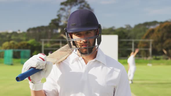 Cricket player with helmet and bat looking at the camera