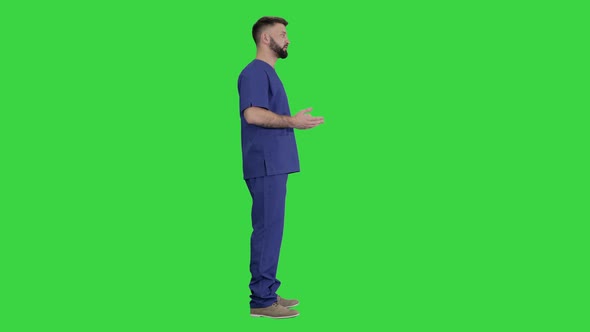 Male Medical Practitioner in a Uniform Talking Explaining Something on a Green Screen, Chroma Key.