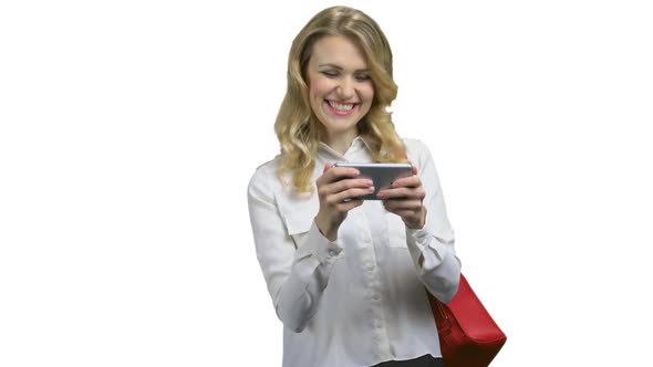 Emotional Young Woman Playing Mobile Game on White Background