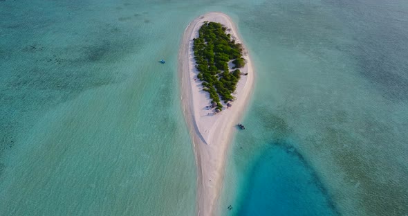 Wide angle overhead island view of a white paradise beach and blue water background in hi res 4K