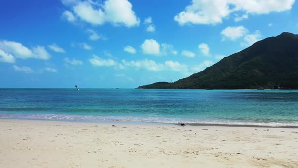 Aerial top down landscape of tranquil tourist beach holiday by blue water and white sandy background