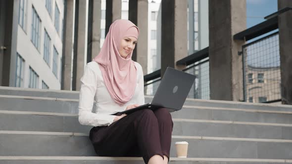 Portrait of Attractive Arabian Woman in Elegant Clothes and Hijab Sitting on