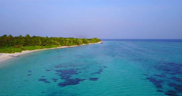 Daytime above island view of a white paradise beach and turquoise sea background