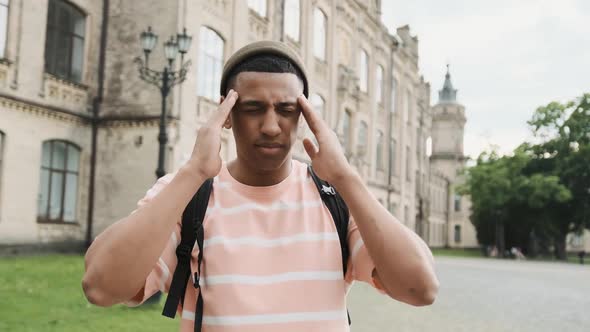 Young African American Man Standing on the Street and Suffering From a Headache and Showing Pharmacy