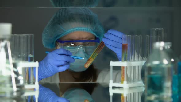 Scientist Looking at Meat Sample in Tube, Writing Down and Analyzing Test Result