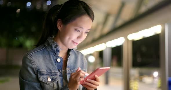 Woman looking at mobile phone at night