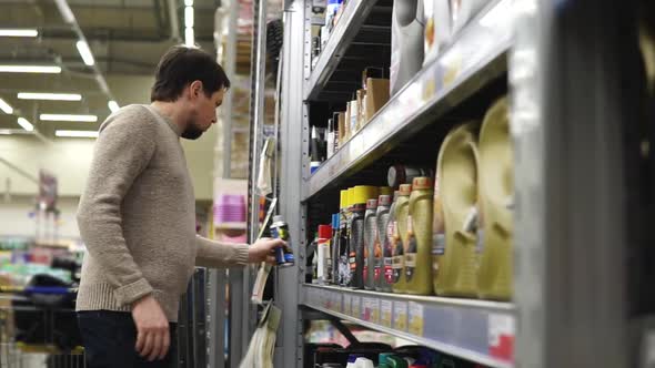 Young Man Choosing Lubricant for His Car