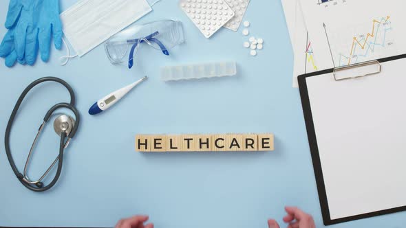 Word Healthcare of Wooden Cubes is Made Up of Hands on a Medical Table