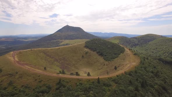 Aerial travel drone view of the Puy de Dome, lava dome volcano in France.