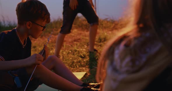 Teenaged Boy Trying Roasted Marshmellow at Campsite