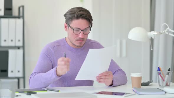 Middle Aged Man Reading Documents