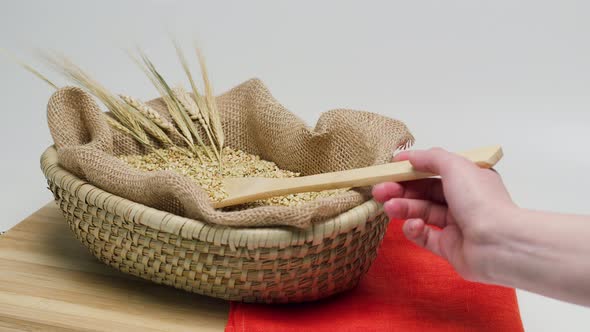 Falling Green Buckwheat From Wood Spoon Into Wicker Basket