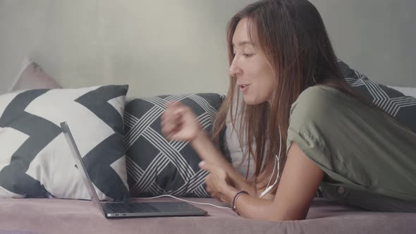 Woman Using Laptop Lying on Couch