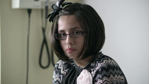 Slow motion of young girl in doctors office looking up.