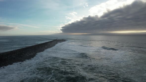 Powerful sea waves crashing on rocks at sunset