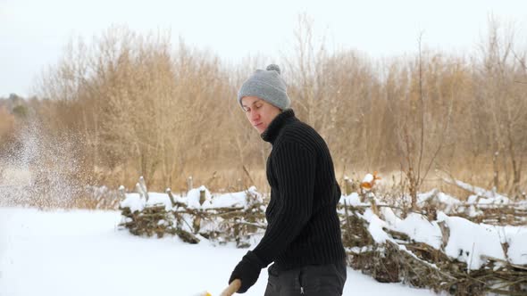 Young Man Throwing Snow with Yellow Plastic Shovel