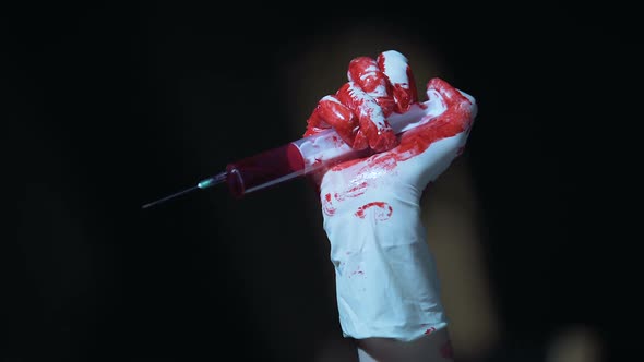 Crazy Murderer Holding Syringe With Dripping Blood and Enjoying Terrible View