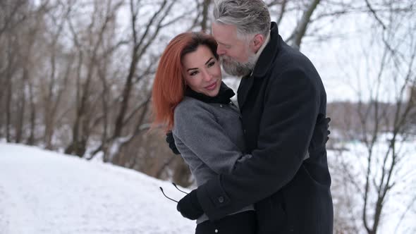 A man and a woman kissing in the park, the camera