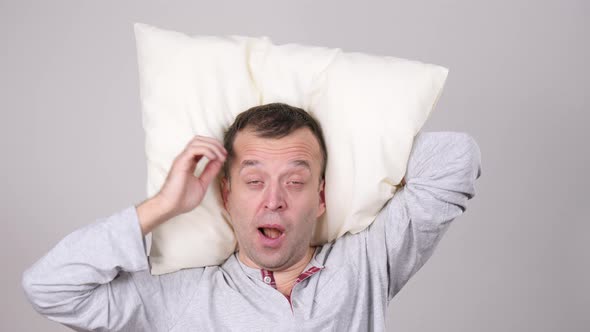 Man Sleepy Tired With Pillow Yawning On Grey