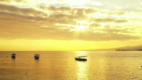 Traditional Balinese fishing boats floating on the calm sea. Beautiful golden sun coming out through