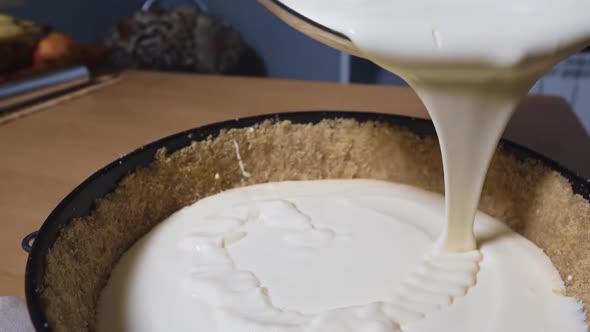 Woman Make Cheesecake. Pouring Cream.