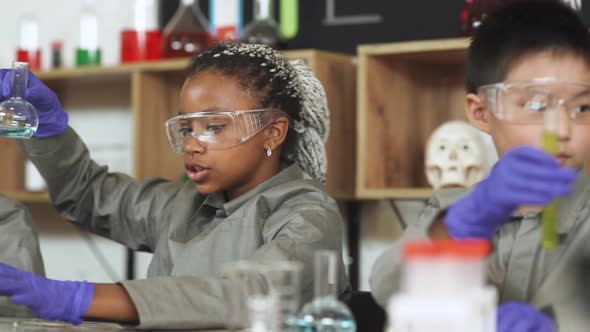 Laboratory Experience in a Chemistry Lesson, Kids in Protective Glasses Holding a Flasks with a