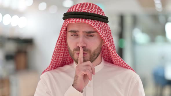 Portrait of Serious Arab Businessman Putting Finger on Lips 