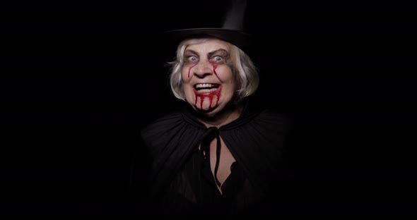 Old Witch Halloween Makeup. Elderly Woman Portrait with Blood on Her Face