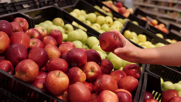 Closeup of a Woman Choosing Red Apples in a Supermarket