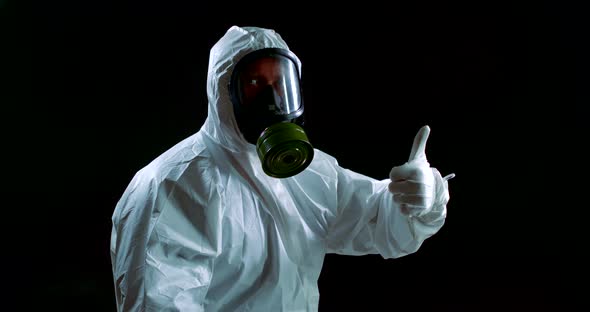 Portrait of a Man in a White Protective Suit, Hood, Gloves and Gas Mask on a Black Background. He