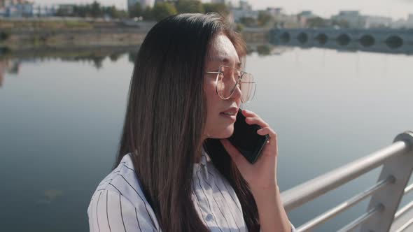 Asian Businesswoman Talking on Smartphone Outdoors