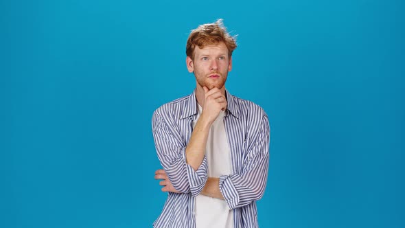 Pensive Man Touches Beard Looking to Sides and Thinking