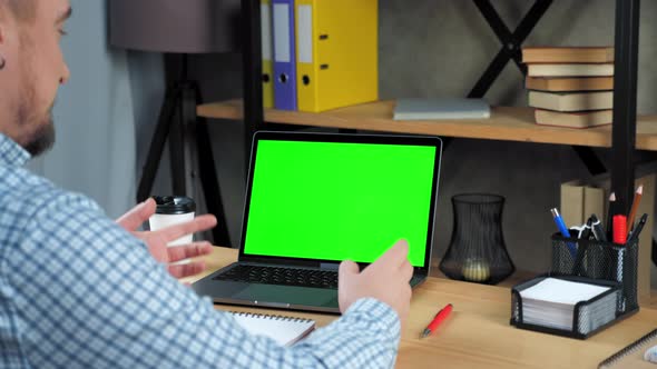 Green screen laptop concept: Smiling businessman tells online video call meeting