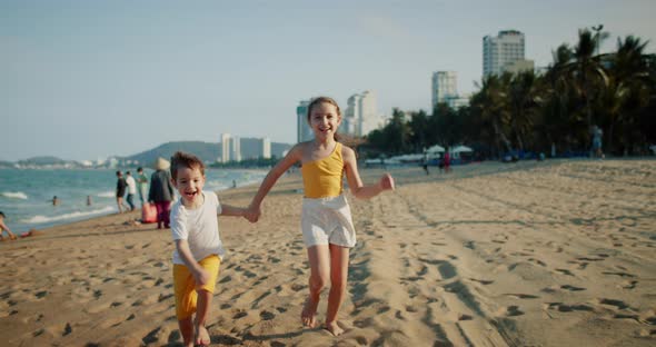 Happy Young Kids Running Down Beach Playing with Their Dog Family Beach Vacation