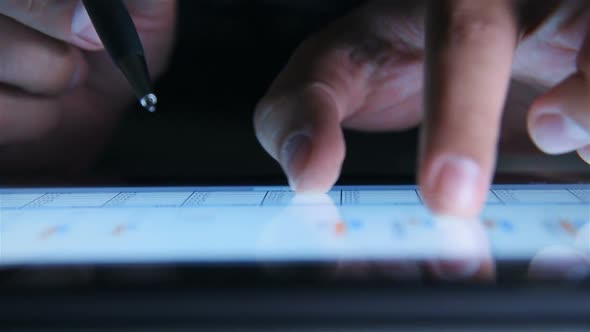 Businessman Hand With Pen Analyzing Annual Report