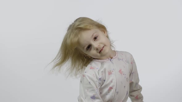 Little Beautiful Baby Girl in Pajama Looking at Camera. White Background